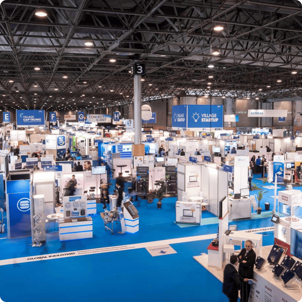 Modern exhibition booths at a tech trade show with attendees exploring new innovations.