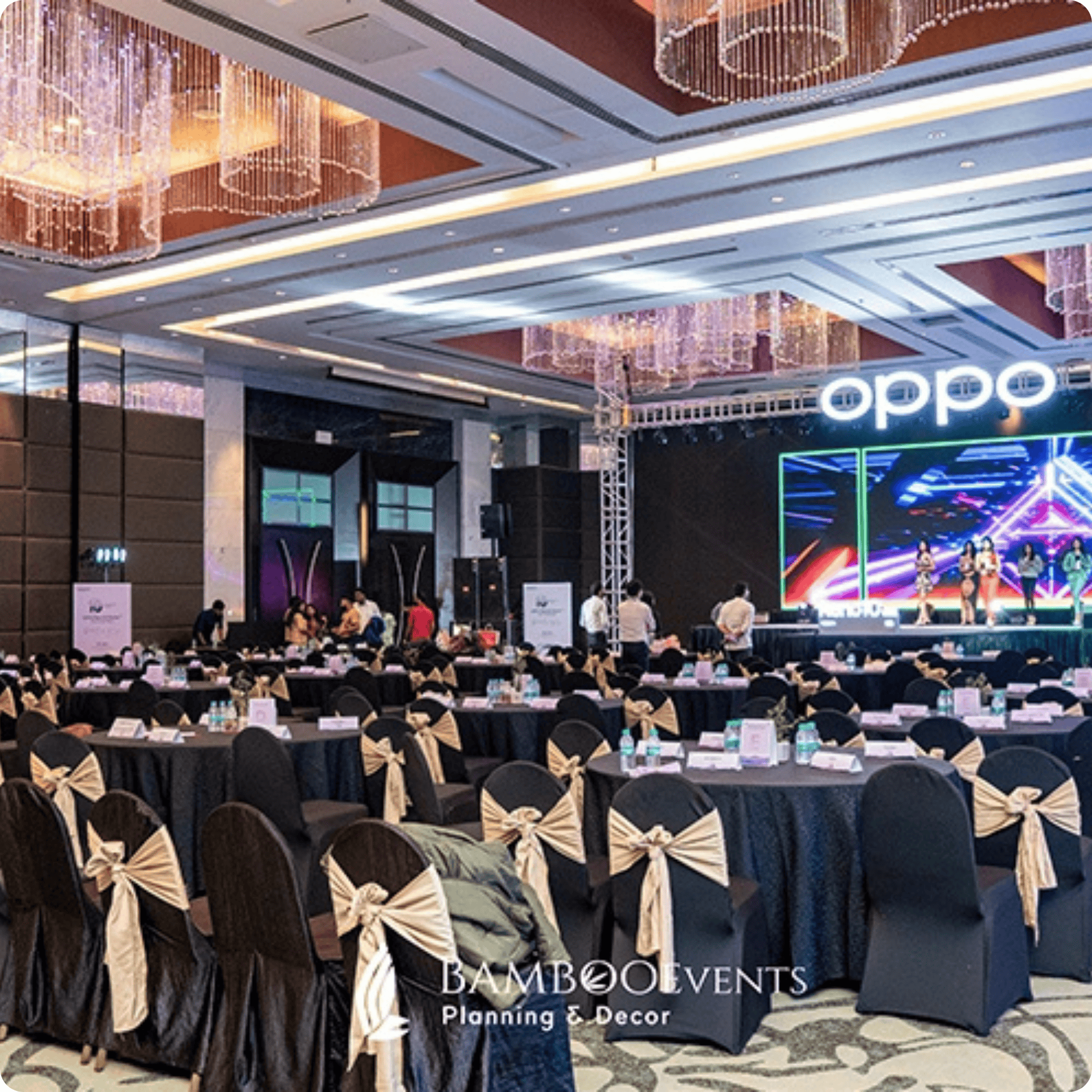 Corporate event setup with stage, lighting, and decorated seating.