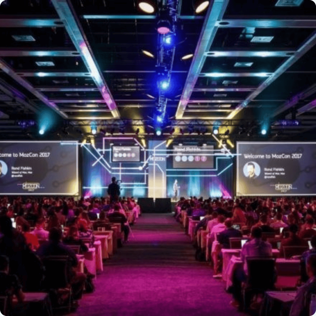 Conference stage with large screens and vibrant lighting, hosting a professional event with an engag.